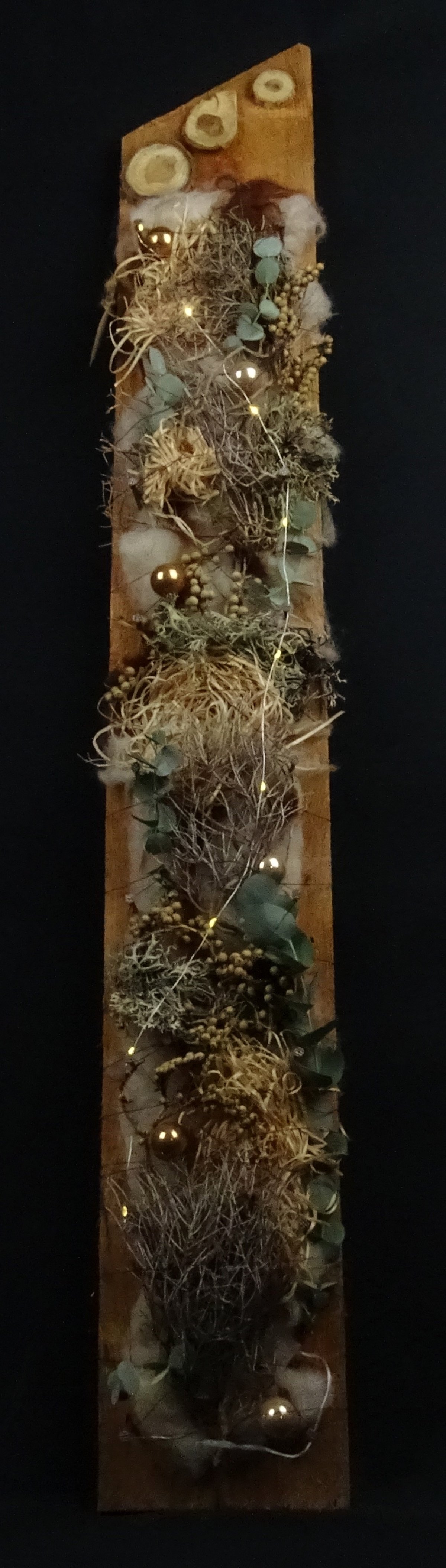 Hausbrett mit Eukalyptus, Goldkugeln und Lichterkette