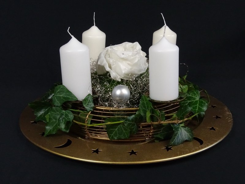 Adventsgesteck auf goldenem Sternteller