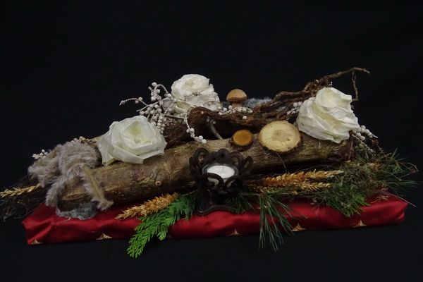 Rustikales Gesteck auf Holzstämmen mit weißen Rosen und Teelichthalter als Geschenk aus Holz