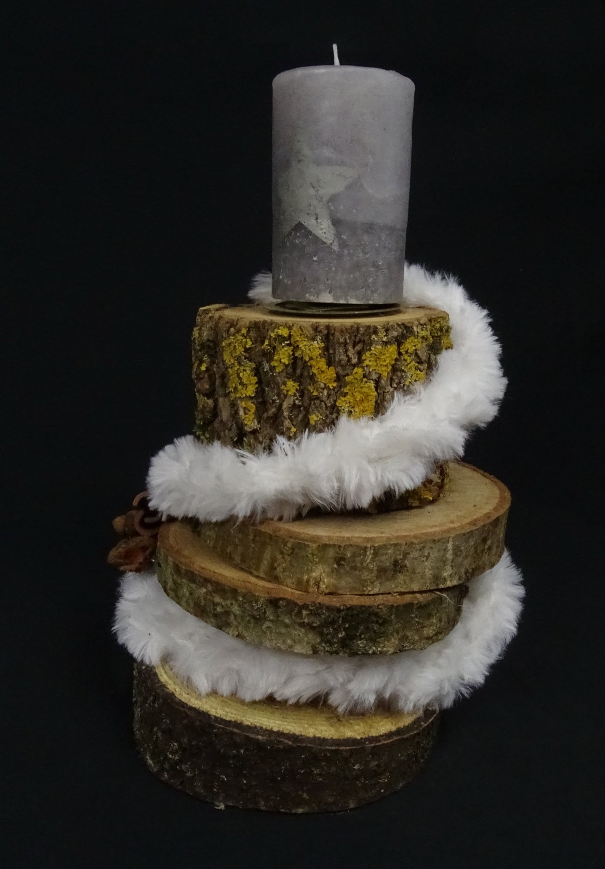 Vierstöckige Baumscheiben mit Sternkerze und Fell