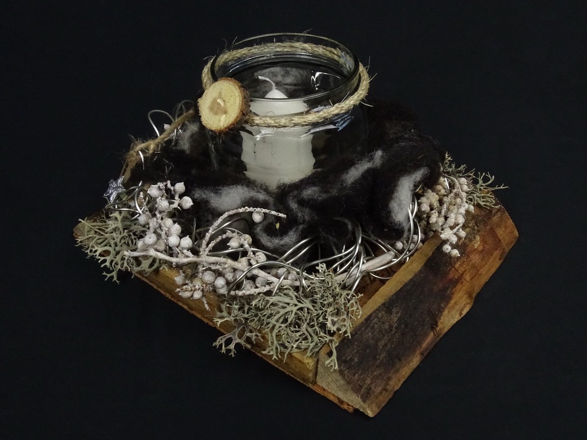 Windlicht mit schwarzer Wolle auf Holzplanke