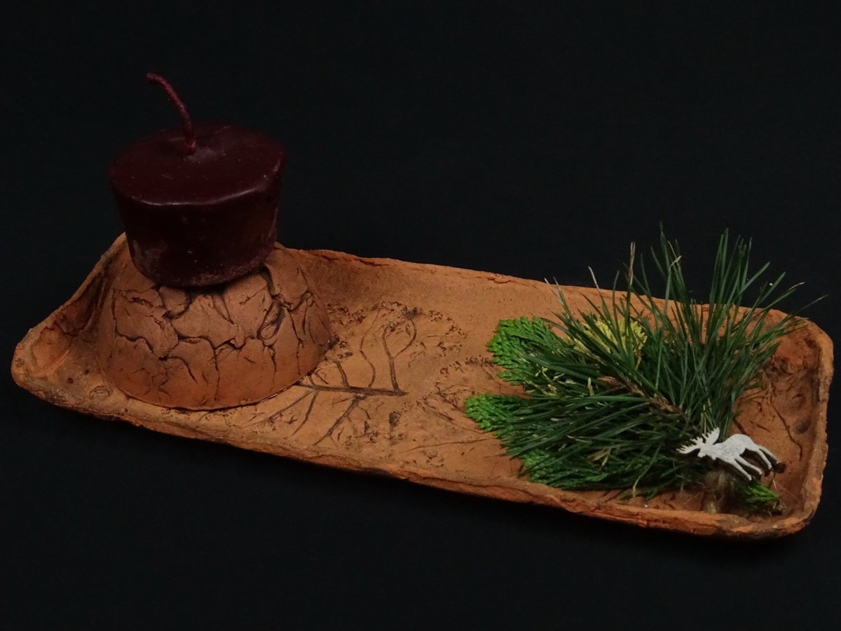 Länglicher Tonteller mit dunkelroter Kerze und Elch