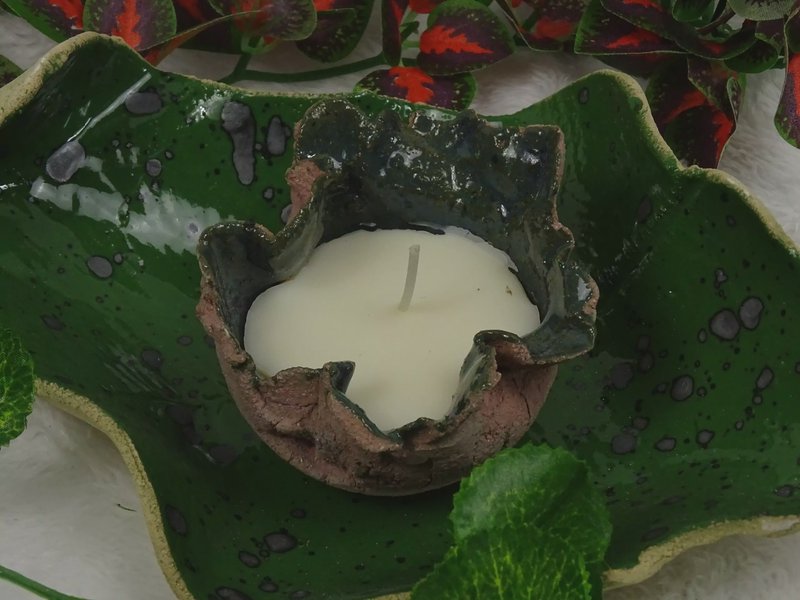 Keramik-Wachslicht auf grünem Tonteller