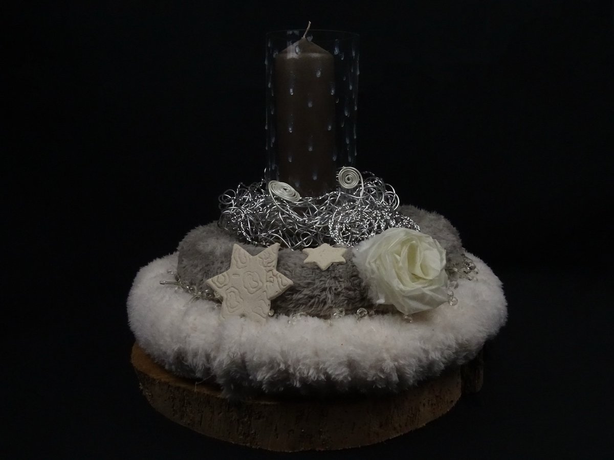 Gesteck mit Fellkranz und Tonsterne auf Baumscheibe