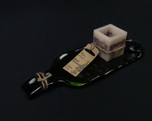 Eingeschmolzene Glasflasche mit handgegossener Wachskerze