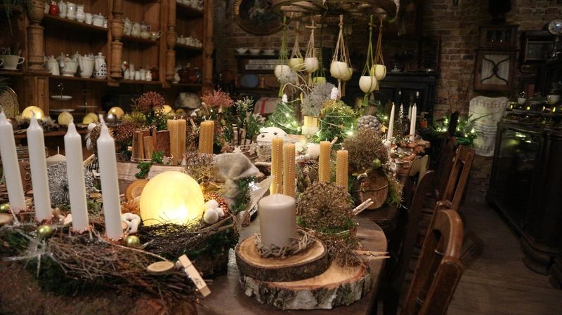 Adventsausstellung mit Bienenwachskerzen, Kränzen und Naturdekorationen auf Birkenscheiben